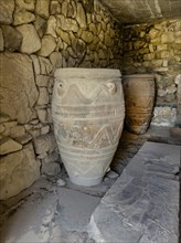 View into historical storeroom below present floor level with large decorated clay vessels Pithoi