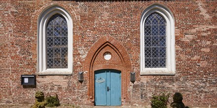 Window and entrance door to St Laurentius Church in Toenning, North Friesland district,