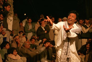 Actor playing a joyous scene, crowd in the background, action is taking place in a muslim cemetery