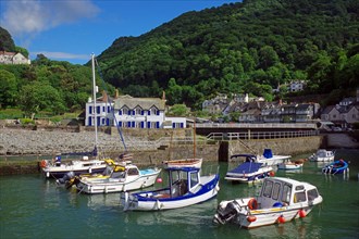 Small harbour, fishing boats and a small village in a hilly landscape, North Devon. Great Britain