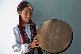 Traditionally dressed girl holding a drum, Wakhan valley, Tajikistan. She is nizari ismaili