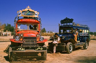 Colourful buses, bus drivers and helpers waiting for passengers, Punjab province, Pakistan, Asia