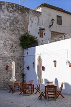 Tables and chairs of a small cafe in the white town of Vejer in the mountains, Andalusia, Spain,