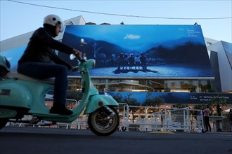Cannes, France, 13 May 2024: A moped rides in front of the Palais des Festivals et des Congres on