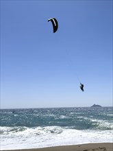 Kitesurfer Kitesurfer takes off in strong wind and waves rough sea moving sea flies with inflated