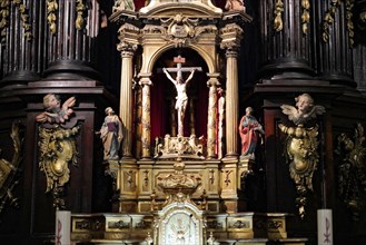Iglesia San Nicolas de Bari, A richly decorated baroque altar with a crucifix surrounded by figures