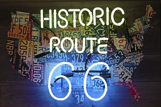 Neon sign with inscription Historic Route 66 in front of USA map