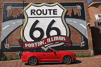 Red Ford Mustang convertible in front of the mural with the motif Route 66, Pontiac, Illinoi