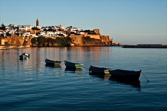 Moored boats on the Bou regreg river, Kasbah of the Udayas in the background, Rabat, Morocco,