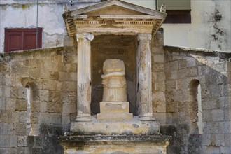 Doric columns at a historical site, temple pediment, sculpture with snake, shows signs of