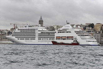 Cruise ship SILVERSEA, against the backdrop of Istanbul and the Galata Tower on a cloudy day,