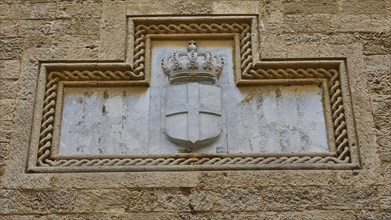 Weathered stone relief of a crowned coat of arms in a wall niche, Grand Master's Palace, Knights'