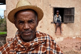 Portrait of a man from the Betsileo ethnic group, In the background, his grand daughter. The man is