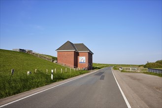 Country road, dyke and dyke house with stairs to the top of the dyke near Tetenbuell, Nordfriesland