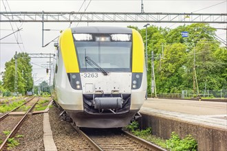 Commuter train entering the platform on a railway station a summer day