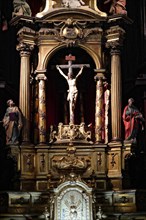 Iglesia San Nicolas de Bari, A baroque altar with a crucifix and figures of saints, richly