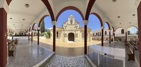Panoramic photo view through archway to main entrance portal of orthodox church monastery church