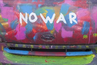 Lettering No War, kein Krieg, colourfully painted vintage car, colour surface, Germany, Europe