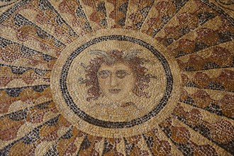Detailed antique mosaic of a female face representing the sun, head of Medusa, interior view, Grand