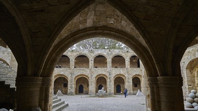 Architecture of a historic courtyard with Gothic arcades, indicates medieval construction, outdoor