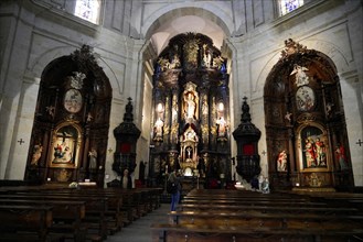 Iglesia San Nicolas de Bari, altar in a baroque church with people sitting in the pews, ornate