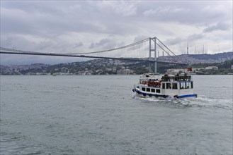 Ship passes under a large suspension rope bridge, Istanbul, Istanbul Province, Turkey, Asia