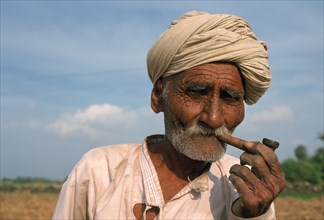 Portrait of an old farmer smoking a pipe, man from the Rabari caste, Gujarat, India, Asia