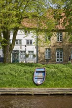 Old wooden boat and historic houses on Mittelburggraben in Friedrichstadt, North Friesland