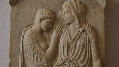 Krito and Timarista, close-up of an ancient bas-relief, two woman in classical dress, intimate