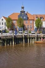Skipper's house and harbour basin with boats in Toenning harbour, Nordfriesland district,