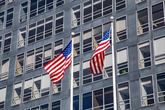 Two US flags on a glass facade in the financial district, Manhattan, New York City