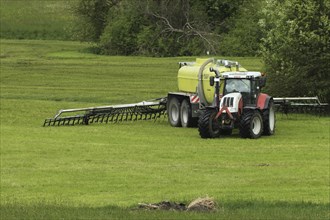Farmer spreading liquid manure on mown meadow, Allgaeu, Bavaria, Germany, Europe