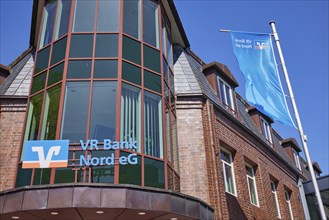 Logo of Volksbank Raiffeisenbank VR Bank Nord eG with flags at the Niebuell branch, Nordfriesland