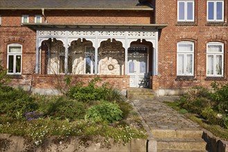 Entrance area to a brick building with front garden in Schafstedt, Dithmarschen district,