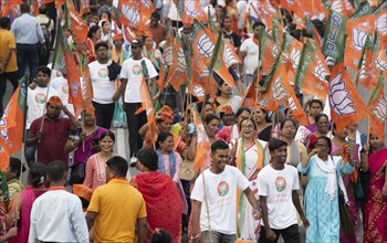 Bharatiya Janata Party (BJP) supporters holding BJP flags arrives to to see a roadshow of Union