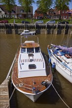 Motorboat with cabin and wooden deck in Toenning harbour, North Friesland district,