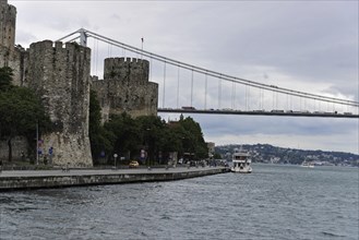 A medieval castle with a small boat on the water in front of a bridge, Istanbul, Istanbul Province,