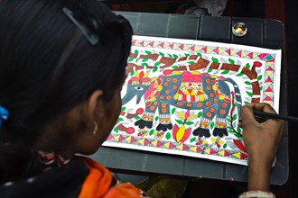 Teenage girl taking drawing lessons in a drawing school, learning the Madhubani style of painting,