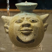 Aryballos, in the shape of the head of Acheloos, a river god, in antique ceramic vessel with funny