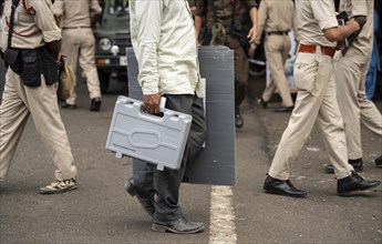 Barpeta, India. 6 May 2024. Polling officials carries Electronic Voting Machines (EVMs) and Voter