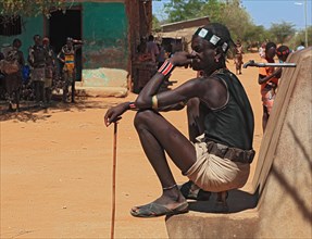 South Ethiopia, Omo region, in the village of Turmi, young man sitting at the waterhole, well, the