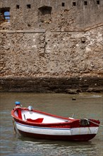 Small fishing boat anchored in front of the historic city wall in Cadiz, Andalusia, Spain, Europe