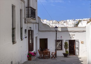 Tables and chairs of a small street cafe in the white town of Vejer in the mountains, Andalusia,