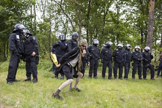 Democlown jokes in front of a police line at the demonstration Wasser. Forest. Justice against the