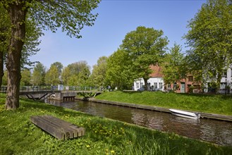 Kohbruech bridge and public wooden bench on the bank of the Mittelburggraben in Friedrichstadt,