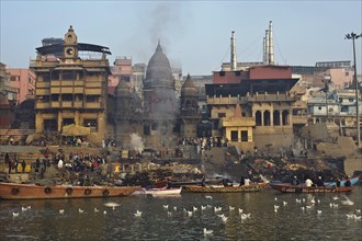 Manikarnika ghat, the main cremation ground in Varanasi, India. Ganges river and gulls in the