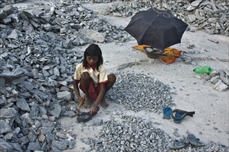 Schoolgirl breaking stones in a quarry, Jharkhand, India. After completing her school day, she