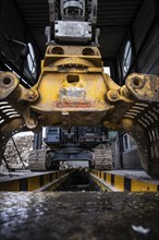 Close-up of an excavator with grab arm carrying out demolition work indoors, demolition,