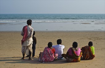 Indian family watching the sea, sitting on the beach, Bay of Bengal, Puri, Odisha, India, Asia