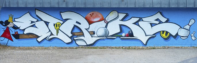 Large graffiti on a wall with the word 'strike' surrounded by colourful elements, painting of the